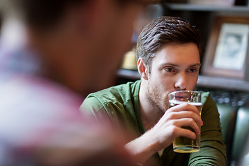 Image showing happy man with friend drinking beer at bar or pub