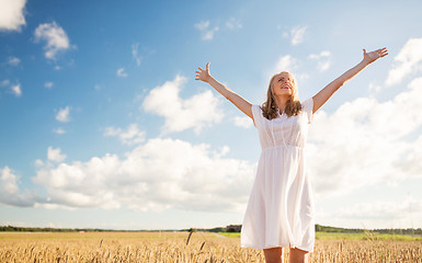 Image showing smiling young woman in white dress on cereal field