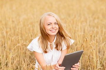 Image showing happy young woman with tablet pc on cereal field