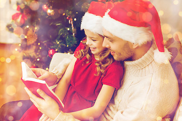 Image showing smiling father and daughter reading book