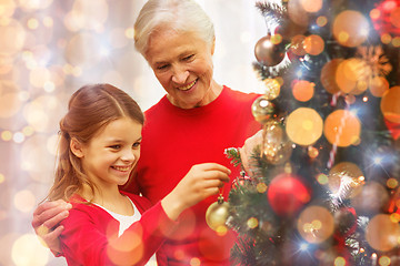 Image showing smiling family decorating christmas tree at home