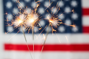 Image showing close up of sparklers burning over american flag