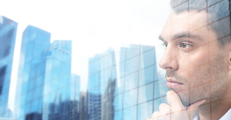 Image showing close up of male face over office buildings