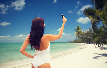 Image showing young woman taking selfie with smartphone on beach