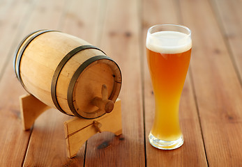 Image showing close up of beer glass and wooden barrel on table