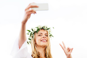 Image showing woman taking smartphone selfie and showing peace