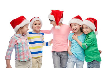 Image showing happy little children in santa hats hugging