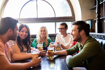 Image showing happy friends drinking beer at bar or pub