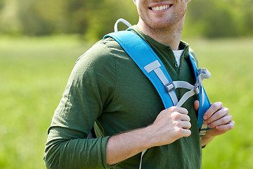 Image showing close up of happy young man with backpack hiking