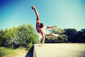 Image showing sporty young man jumping in summer park