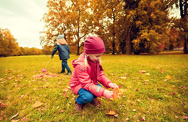 Image showing children collecting leaves in autumn park