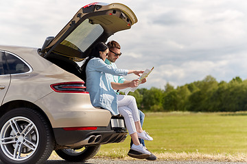 Image showing happy man and woman with road map at hatchback car