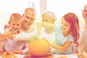 Image showing happy family sitting with pumpkins at home