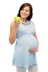 Image showing happy pregnant woman looking at green apple