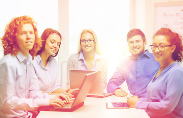 Image showing smiling team with laptop and table pc computers