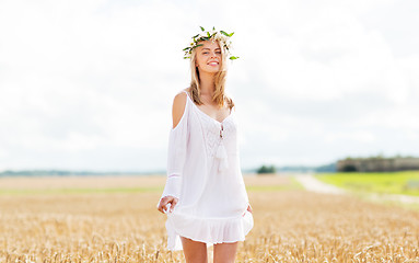 Image showing happy young woman in flower wreath on cereal field