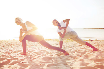 Image showing couple making yoga exercises outdoors