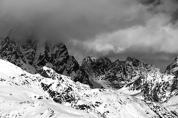 Image showing Black and white snowy rocks in clouds at sunny day