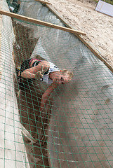 Image showing Girl creeps on an entrenchment with sand and water