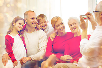 Image showing smiling family with camera at home