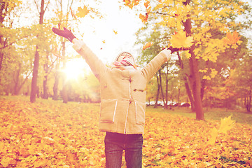 Image showing smiling little girl with autumn leaves in park