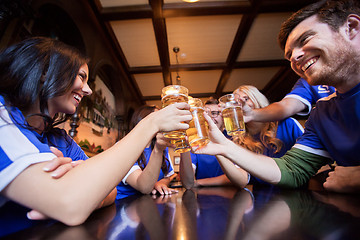 Image showing football fans clinking beer glasses at bar or pub