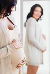 Image showing close up of pregnant woman looking to mirror