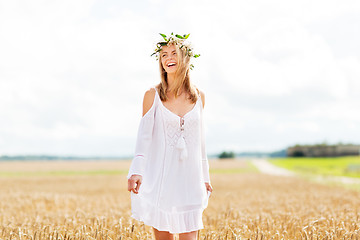 Image showing happy young woman in flower wreath on cereal field