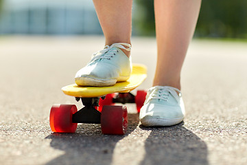Image showing close up of female feet riding short skateboard