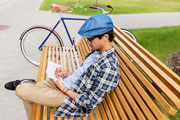 Image showing man with notebook or diary writing on city street