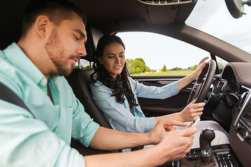 Image showing man and woman with smartphones driving in car