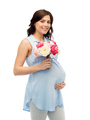 Image showing happy pregnant woman with flowers touching belly