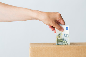 Image showing man putting euro money into donation box