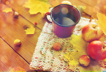 Image showing close up of tea cup on table with autumn leaves