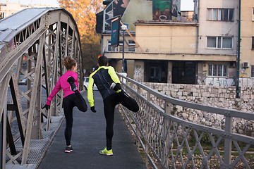 Image showing couple warming up before jogging