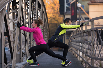 Image showing couple warming up before jogging