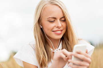 Image showing happy woman with smartphone and earphones