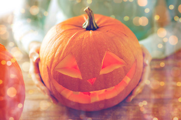 Image showing close up of woman with pumpkins at home