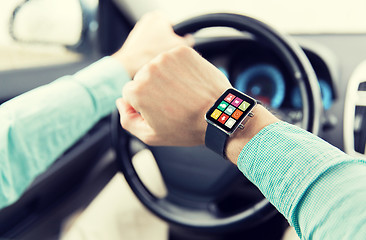 Image showing close up of man with app on smartwatch driving car