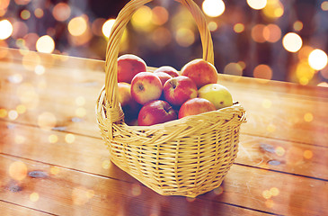 Image showing close up of basket with apples on wooden table