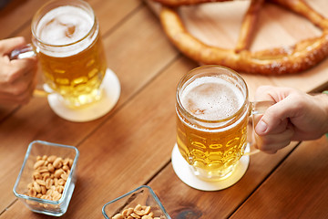 Image showing close up of hands with beer mugs at bar or pub