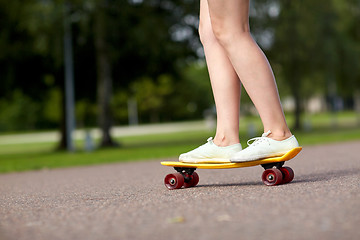 Image showing close up of female feet riding short skateboard