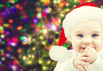 Image showing happy baby in santa hat over christmas lights