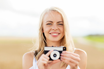 Image showing happy young woman with film camera outdoors