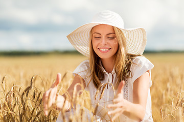 Image showing happy young woman in sun hat on cereal field