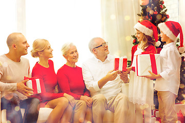 Image showing smiling family with gifts at home