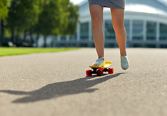 Image showing close up of female feet riding short skateboard