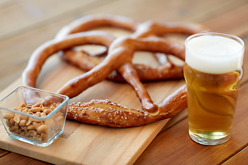 Image showing close up of beer, pretzels and peanuts on table