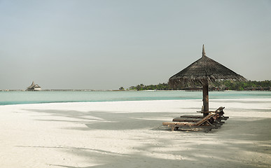 Image showing palapa and sunbeds by sea on maldives beach