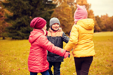 Image showing children holding hands and playing in autumn park